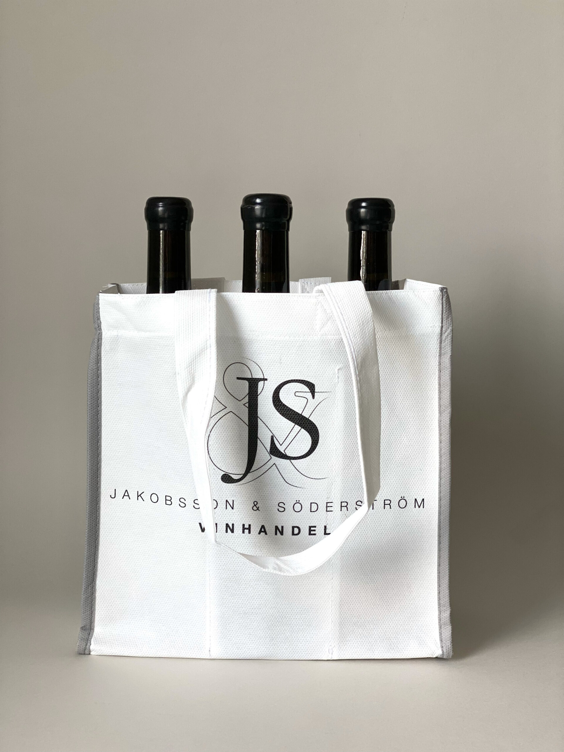 Återanvändbar flaskpåse i non-woven material med tryck. Vit vinpåse med plats för flera flaskor.